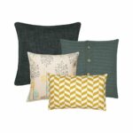 A knitted cushion in grey, one printed cushion in light orange, one grey cushion , and one chevron printed cushion.