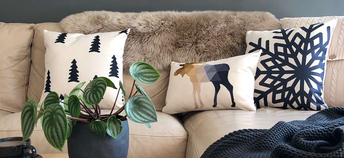 A beige sofa with cushions in navy and white inspired by winter.