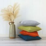 Bright-coloured linen cushions against a white wall