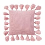 Close up image of pink knitted cushion with tassels