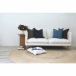 Grey and blue cushions sitting on 2 seater white sofa.