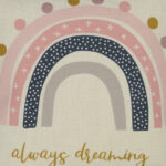 Close up image of kids cushion with pink always dreaming rainbow