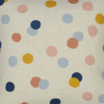Close up photo of square kids cushion with pastel polka dots