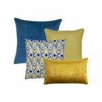 One blue square cushion, one yellow square cushion, one blue and yellow chevron design cushion and a gold velvet rectangular cushion in a set of four.
