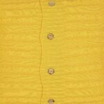 Zoomed photo of bright mustard yellow knit cushion with buttons