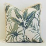 Palmera outdoor cushion with green tropical leaves and fringed edges.