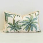 Rectangular Palmera outdoor cushion with palm tree print and fringed trim.