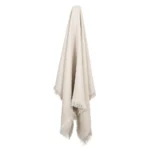 A stone linen throw hangs on a hook.