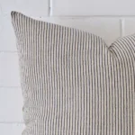 A zoomed in photo of the corner of a striped cushion that has designer fabric and a large size.