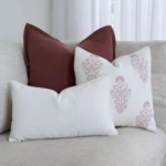 3 couch cushions are neatly arranged on a gray sofa in perfect coordination.