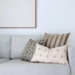 The amaro set of 3 designer couch cushions is displayed on a light grey sofa.