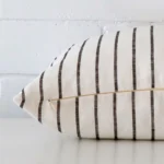 A rectangle cushion cover laying flat. This viewpoint highlights the striped style and linen fabric from a side position.