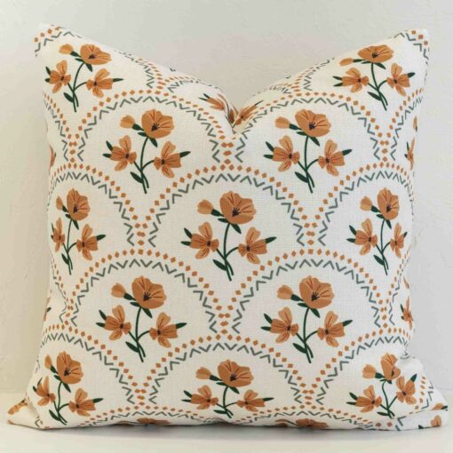 Amora floral scallop cushion with orange flowers and green geometric pattern.