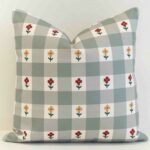 Amora gingham check cushion with small flowers on soft green grid pattern.