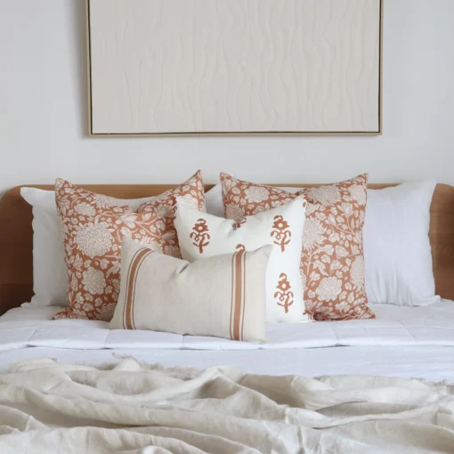 The Aria bed cushions set is neatly arranged on a wooden bed with white bedding.