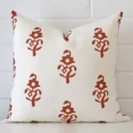 A bold patterned linen cushion in a sleek square size with a terracotta tone of colour.