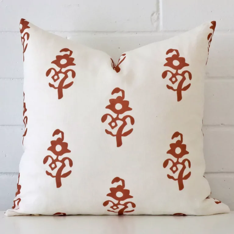 A bold patterned linen cushion in a sleek square size with a terracotta tone of colour.