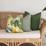 A set of 3 olive outdoor couch cushions sits on a rattan seat.