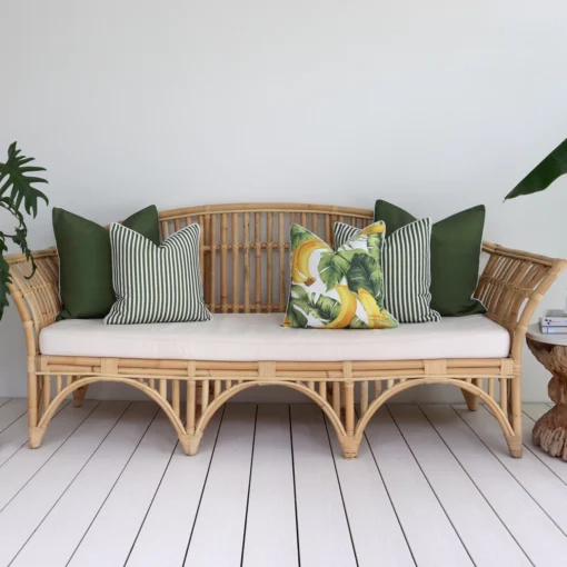 A set of 5 olive outdoor sofa cushions on a rattan seat creating a relaxing vibe.