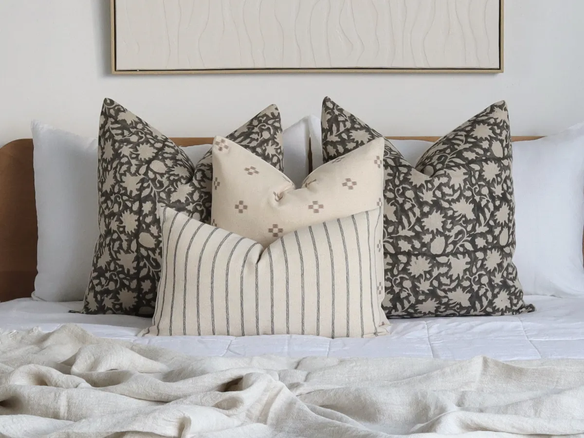 A bed cushion arrangement with large designs placed at back of set.