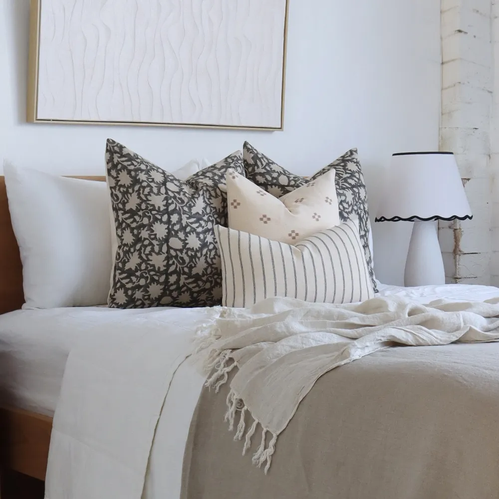 A cushion set is on a bed.