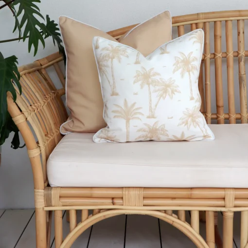 The correct grammar would be: Beige outdoor sofa cushions, including one with palm tree patterns.