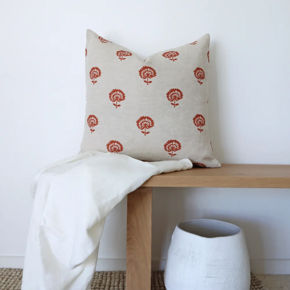 A bench with a throw and a scatter cushion on it.