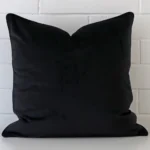 A close up image of this large cushion. The image shows details of its velvet fabric and black colour.