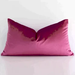 A pretty solid colour velvet cushion cover is shown against a white wall. It features a rectangle shape and a blush colour finish.
