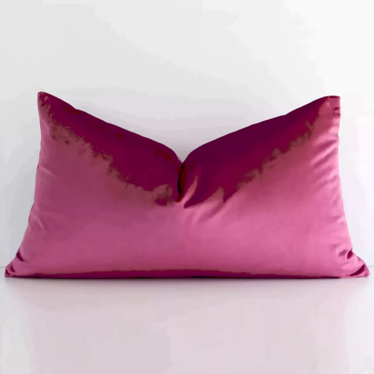A pretty solid colour velvet cushion cover is shown against a white wall. It features a rectangle shape and a blush colour finish.