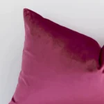 A zoomed view of this velvet blush cushion’s corner that shows a magnified view of its solid colour design and its rectangle shape.