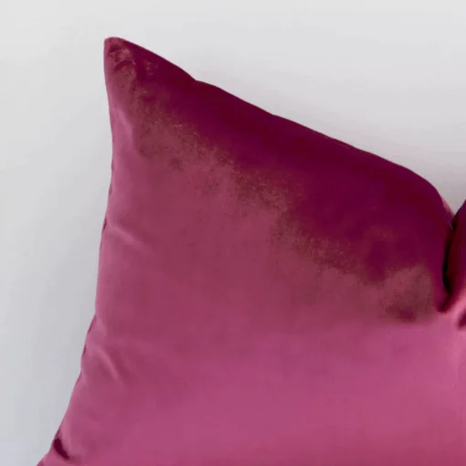 A zoomed view of this velvet blush cushion’s corner that shows a magnified view of its solid colour design and its rectangle shape.