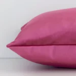 Side shot showing the seam of this rectangular blush cushion that features a solid colour design on its velvet material.
