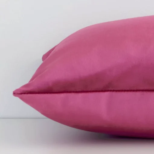 Side shot showing the seam of this rectangular blush cushion that features a solid colour design on its velvet material.