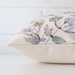 A square cushion cover laying flat. This viewpoint highlights the style and linen fabric from a side position.