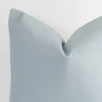 Close up image of top corner of this soft teal cushion. This shows the linen fabric and large size up close.
