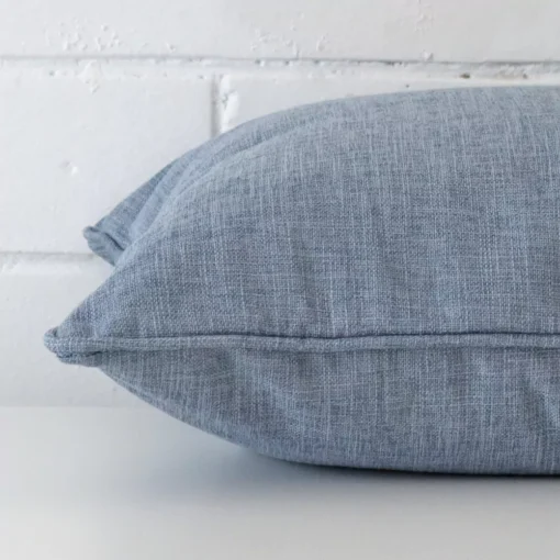 Side angle of light blue cushion cover that has linen fabric and a square size.