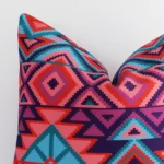 Square geometric cushion sitting upright in front of a white wall. It has been made from a quality outdoor material.