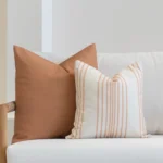 2 outdoor outdoor cushions from the Claybourne set are arranged on a white sofa.