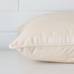 Horizontal edge view of front and back panels of velvet cushion in a large size and with cream colouring.