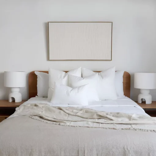 4 cushion inserts made from faux feather on a wooden bed.