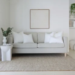 5 cushion inserts made from faux feather are displayed in a bright living room.
