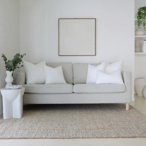 5 cushion inserts made from faux feather are displayed in a bright living room.