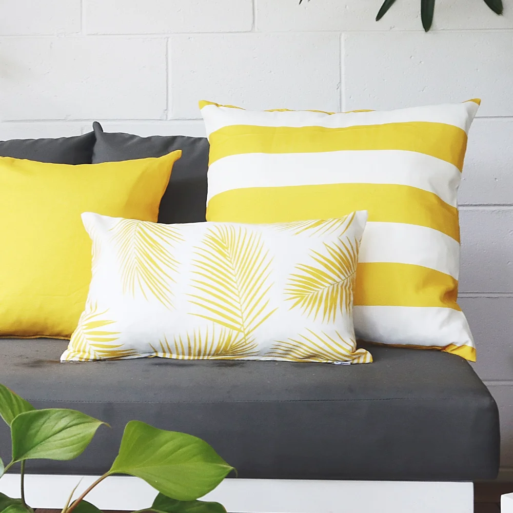Dark seating with styled set of yellow outdoor cushions.