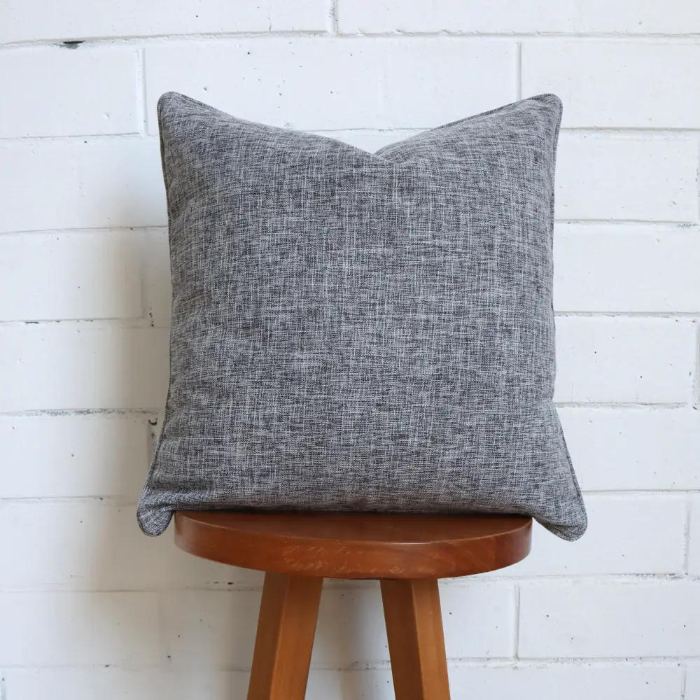 A dark timber high chair with a grey cushion at its top.