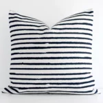 Bold large cushion positioned in front of white wall. Its striped style pops on the linen fabric.