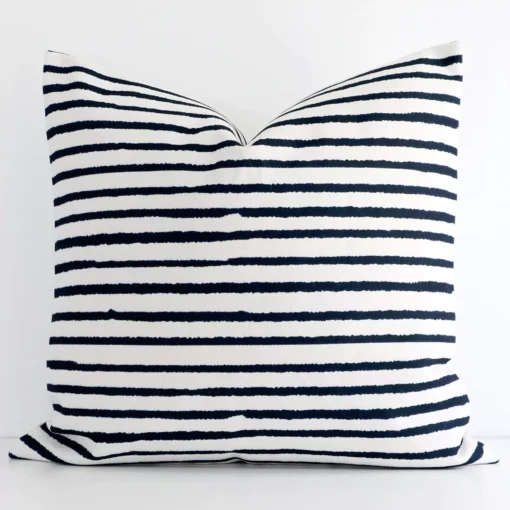 Bold large cushion positioned in front of white wall. Its striped style pops on the linen fabric.