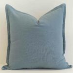 Dusty blue linen cushion with soft muted tone and subtle texture.
