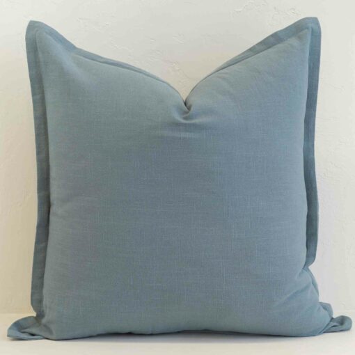 Dusty blue linen cushion with soft muted tone and subtle texture.