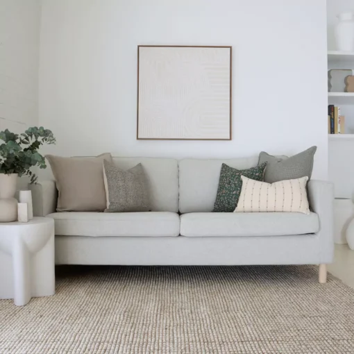A beautiful combination of 5 couch cushions positioned on light grey sofa.